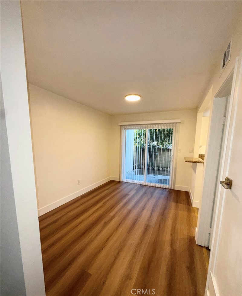 2255 Cahuilla Street, Unit 35 Colton, CA 92324 - Photo 13 of 24 a view of an empty room with wooden floor and a window