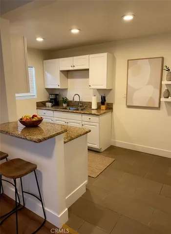 a kitchen with a sink a stove a refrigerator cabinets and dining table