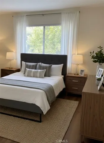 a bedroom with a bed window and a night stand