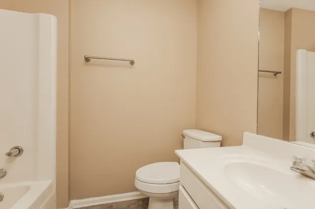 a white toilet sitting next to a bathroom sink