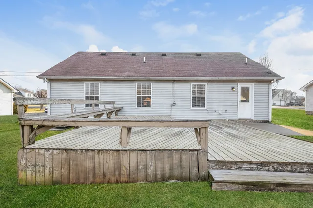 a view of a house with wooden deck and a yard