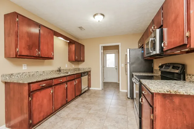 a kitchen with stainless steel appliances granite countertop a sink stove and cabinets