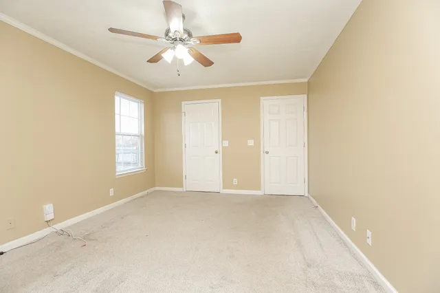 an empty room with windows and ceiling fan