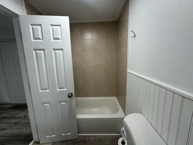 a kitchen with appliances cabinets and a wooden floor