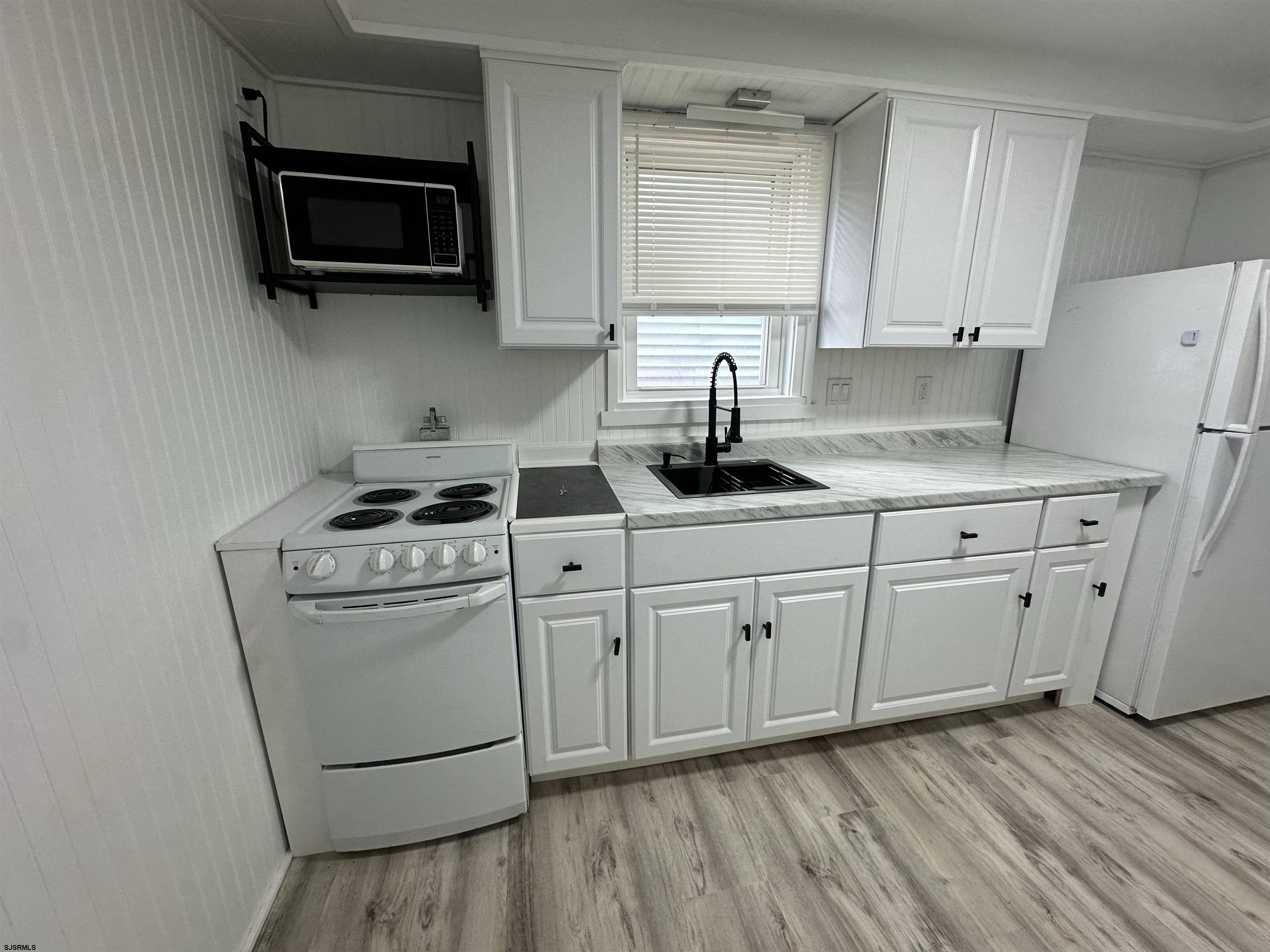 16 South Washington Avenue Margate City, NJ 08402 - Photo 13 of 14 a kitchen with appliances cabinets and a wooden floor
