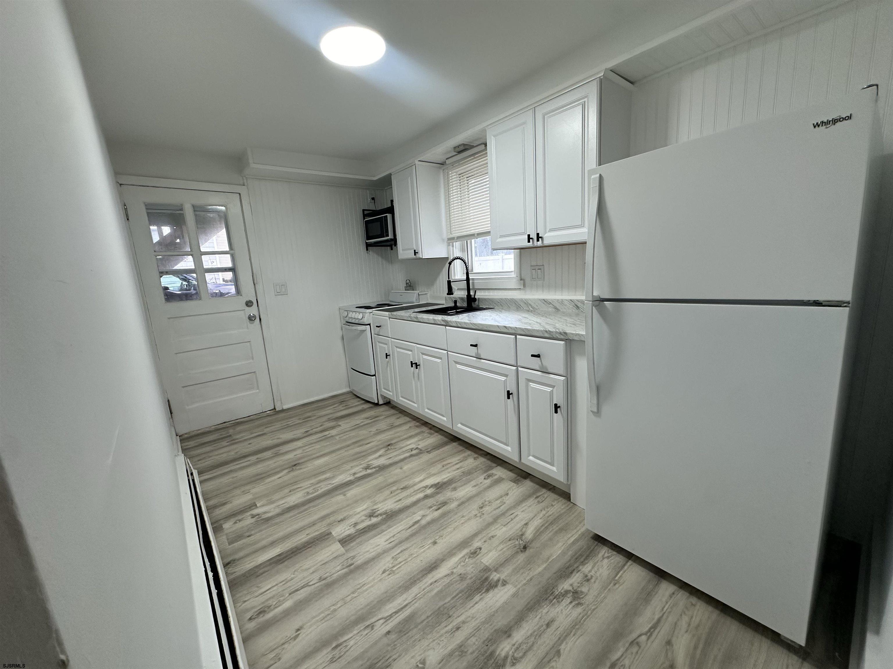 16 South Washington Avenue Margate City, NJ 08402 - Photo 14 of 14 a kitchen with white cabinets and white appliances