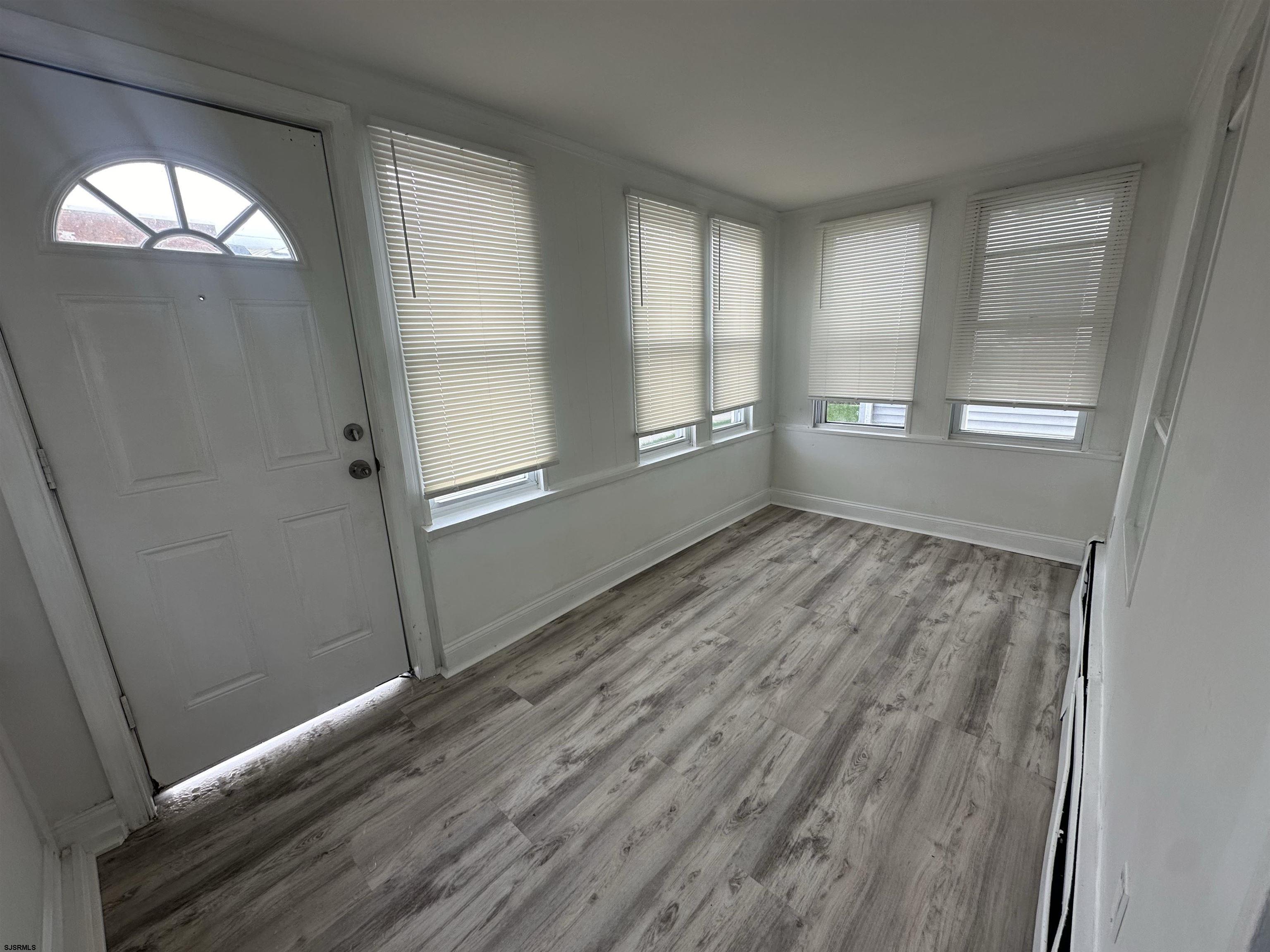 16 South Washington Avenue Margate City, NJ 08402 - Photo 3 of 14 an empty room with wooden floor and windows