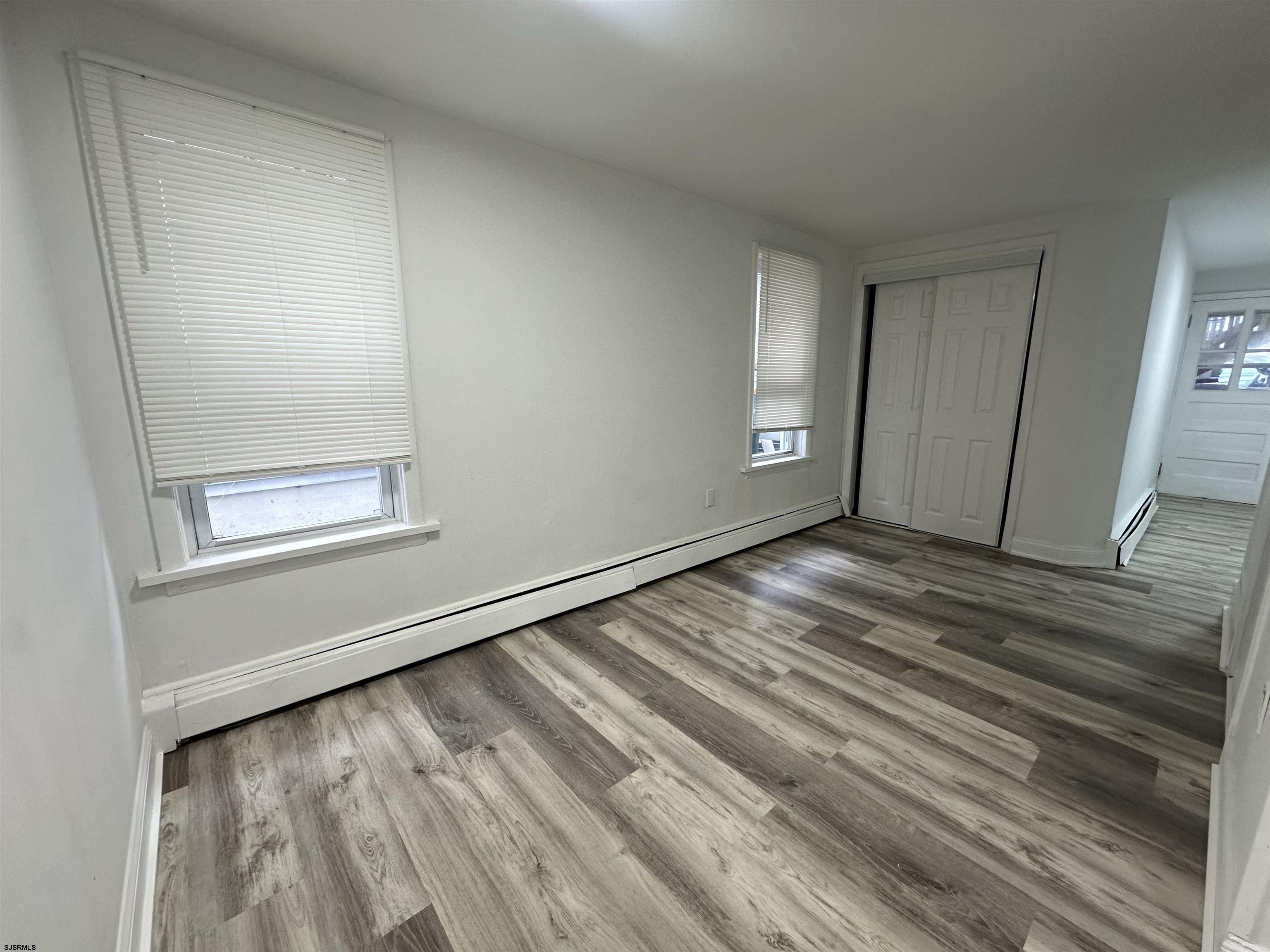 16 South Washington Avenue Margate City, NJ 08402 - Photo 9 of 14 a view of an empty room with wooden floor and a window