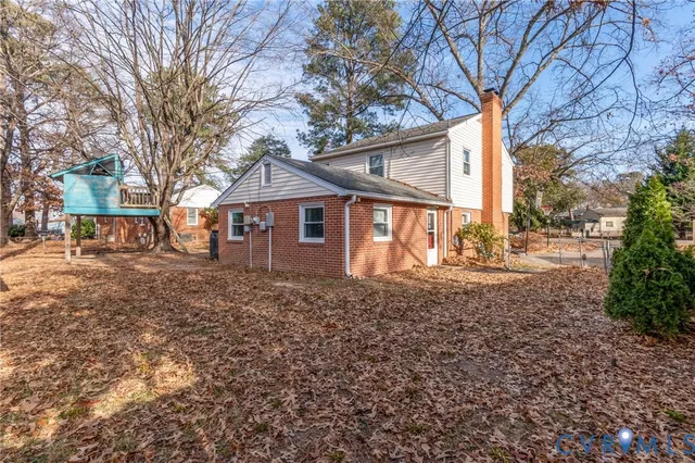 a view of a yard with a house and a large tree