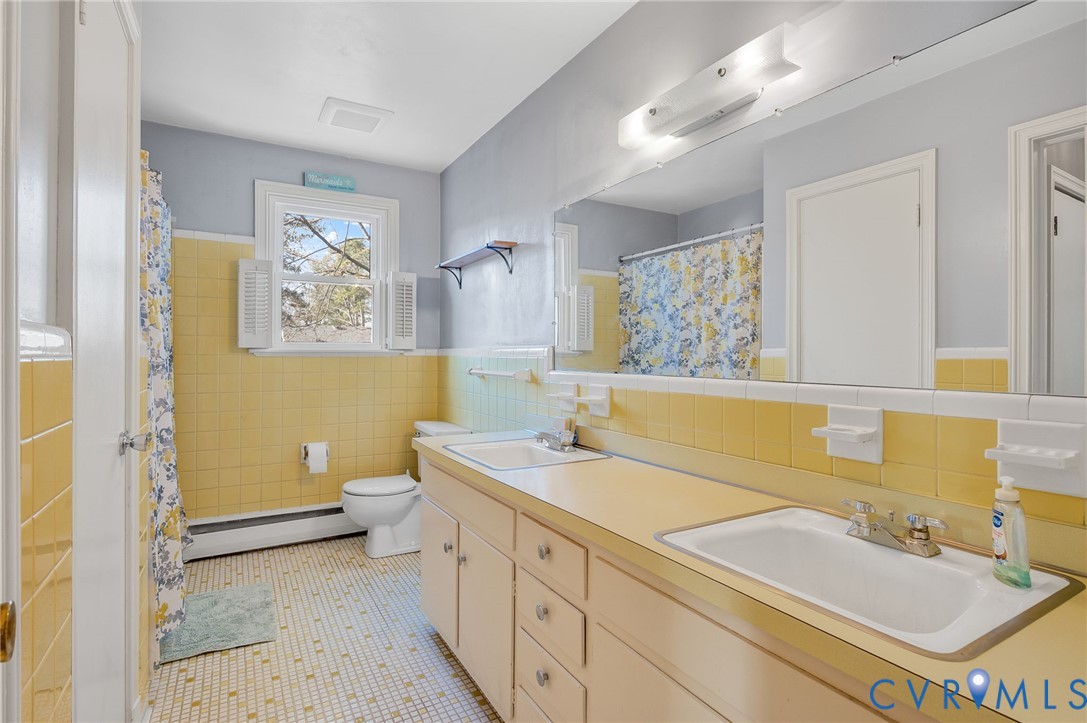 9303 Lawndell Road Henrico, VA 23229 - Photo 28 of 33 a bathroom with a sink a toilet a mirror and vanity
