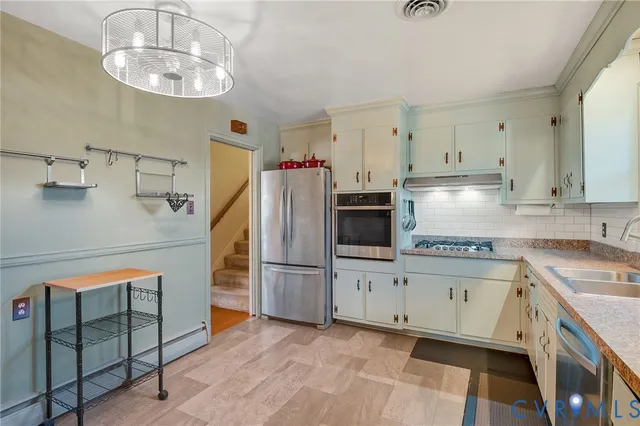 a kitchen with stainless steel appliances a stove refrigerator sink and cabinets