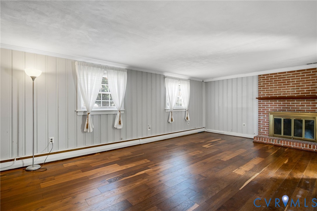 9303 Lawndell Road Henrico, VA 23229 - Photo 10 of 33 an empty room with wooden floor fireplace and windows