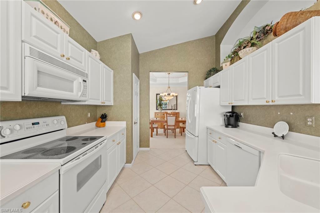 23101 Rosedale Drive, Unit 202 Estero, FL 34135 - Photo 15 of 49 a kitchen with white cabinets and white appliances