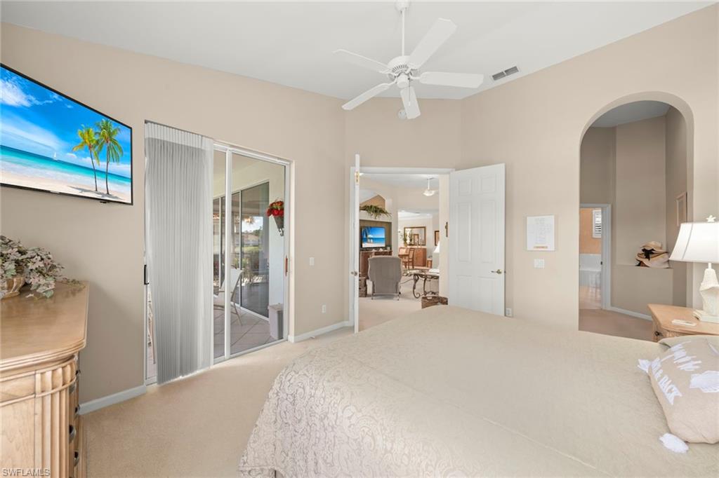 23101 Rosedale Drive, Unit 202 Estero, FL 34135 - Photo 26 of 49 a bedroom with a bed and a chandelier