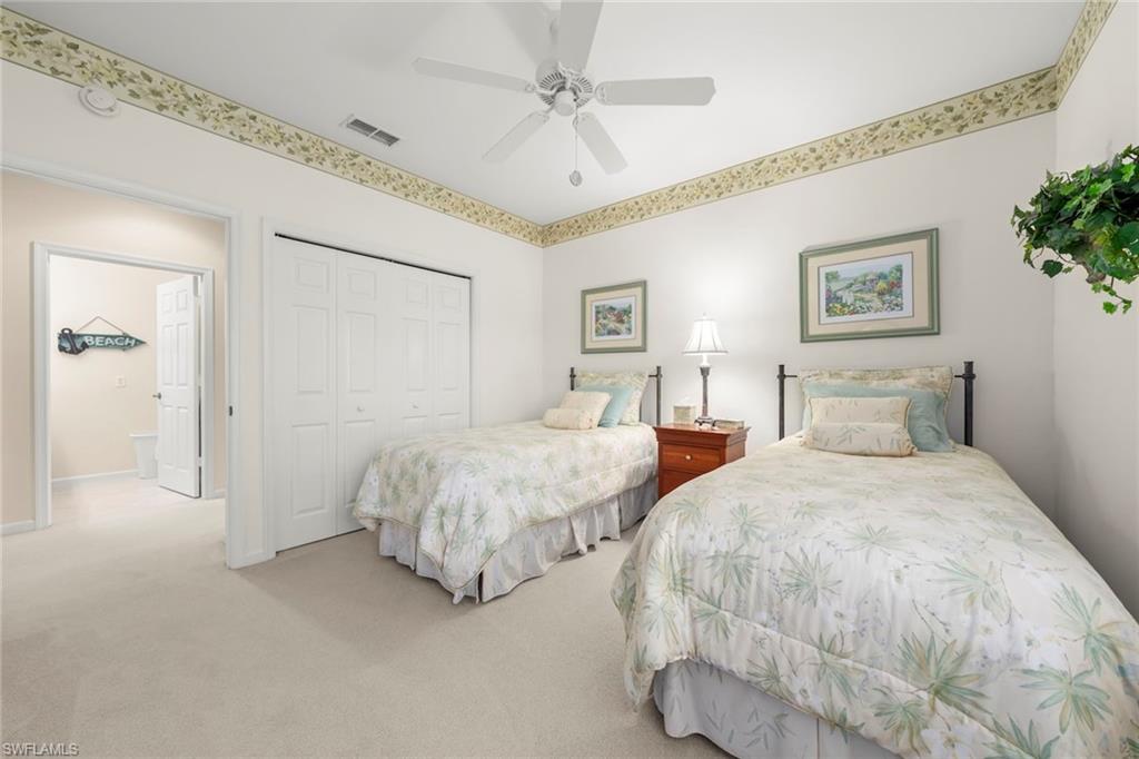 23101 Rosedale Drive, Unit 202 Estero, FL 34135 - Photo 31 of 49 a spacious bedroom with two bed and a chandelier