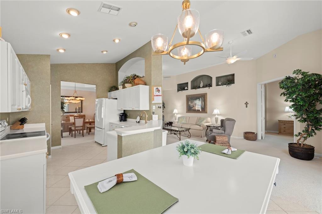 23101 Rosedale Drive, Unit 202 Estero, FL 34135 - Photo 33 of 49 a living room with furniture a chandelier and a dining table