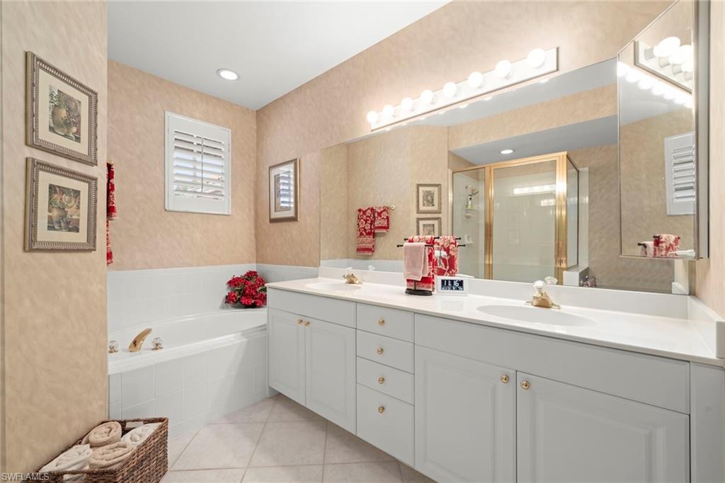 23101 Rosedale Drive, Unit 202 Estero, FL 34135 - Photo 7 of 49 a bathroom with a tub sink double vanity and mirror