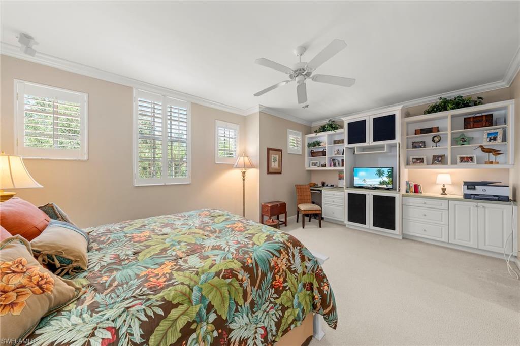 23101 Rosedale Drive, Unit 202 Estero, FL 34135 - Photo 9 of 49 a bedroom with a large bed and a chandelier