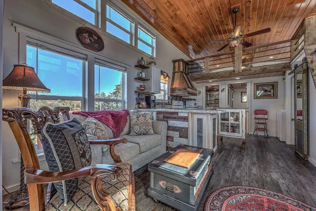 a living room with furniture a flat screen tv and a table