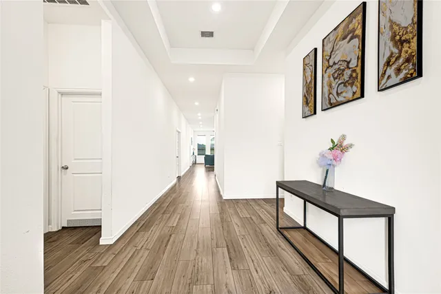 a hallway with wooden floor and furniture