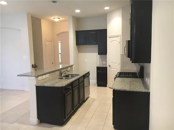 a kitchen with stainless steel appliances granite countertop a stove a sink and a refrigerator