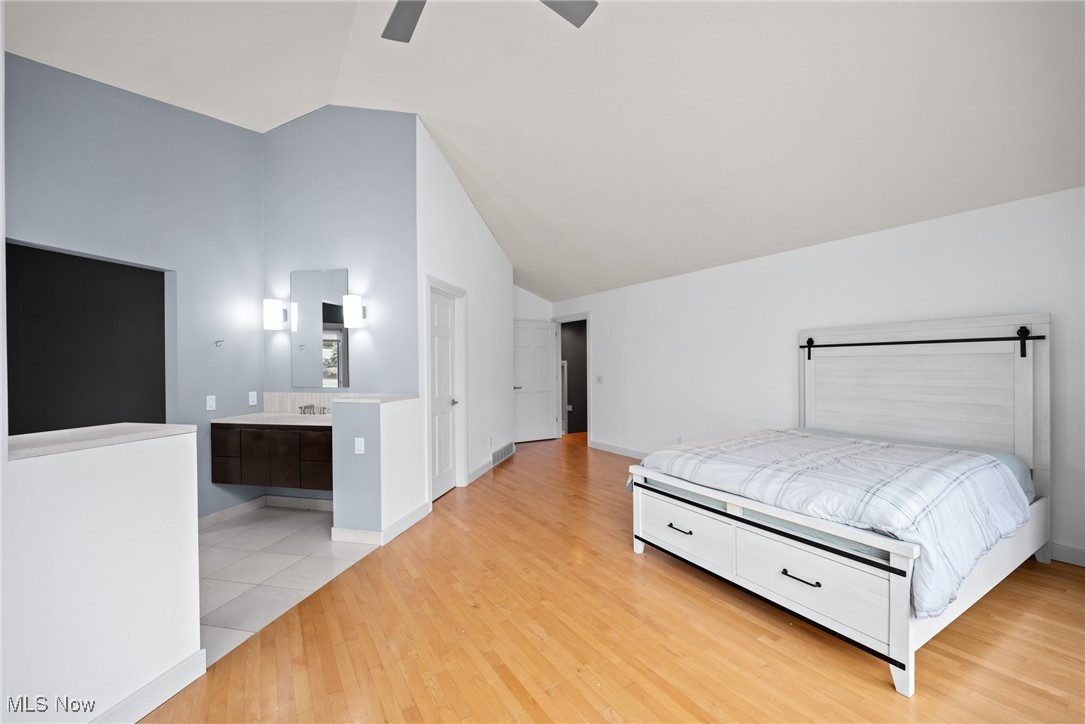2711 Glenmont Road Northwest Canton, OH 44708 - Photo 29 of 42 Bedroom with high vaulted ceiling, light wood finished floors, a ceiling fan, and ensuite bath
