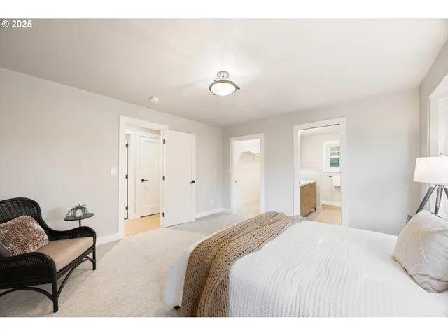 a bedroom with a bed couch and lamp