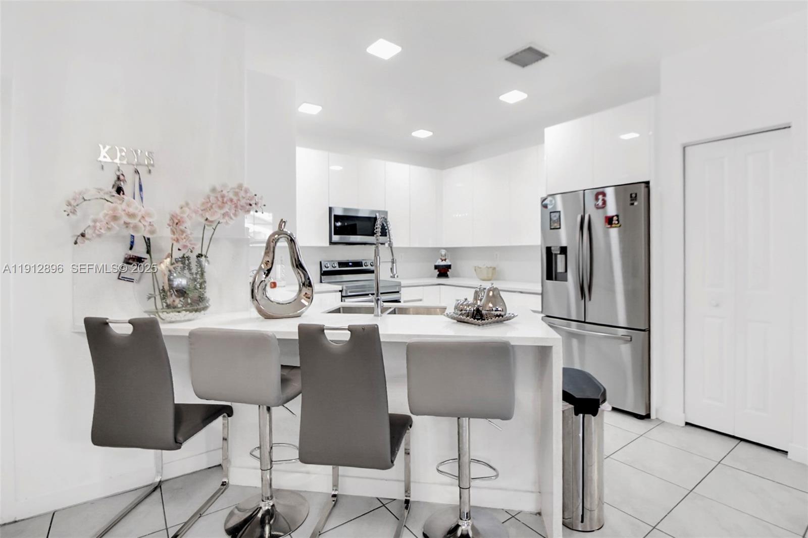 24301 Southwest 117 Path Homestead, FL 33032 - Photo 23 of 50 a kitchen with refrigerator and chairs