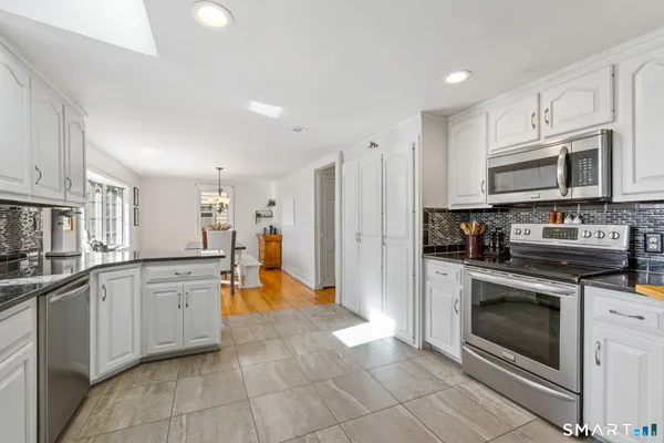a kitchen with stainless steel appliances granite countertop a stove a sink and a refrigerator