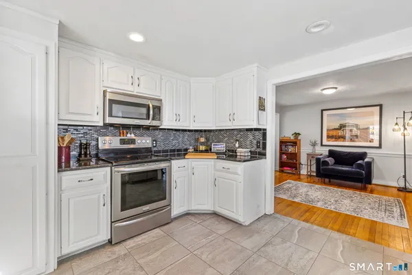 a kitchen with stainless steel appliances granite countertop a stove a sink and a microwave