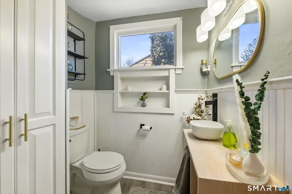 a bathroom with a toilet sink and mirror