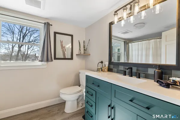 a bathroom with a toilet a sink and mirror