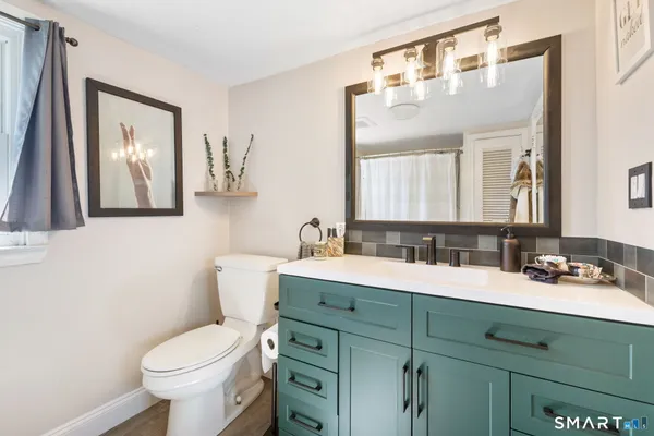a bathroom with a toilet sink and mirror