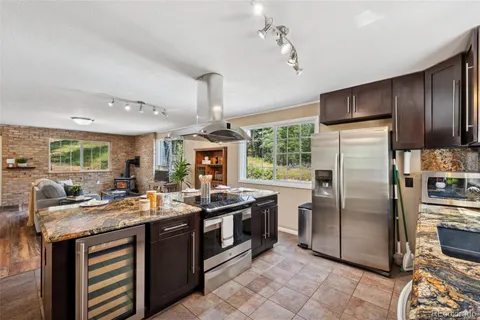 a kitchen with stainless steel appliances granite countertop a sink a stove and refrigerator