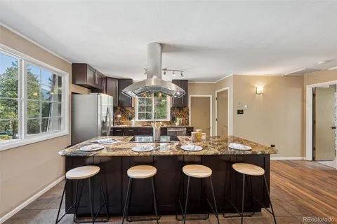 a dining room with granite countertop a sink and chairs