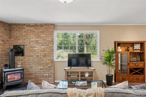 a living room with furniture a flat screen tv and a floor to ceiling window