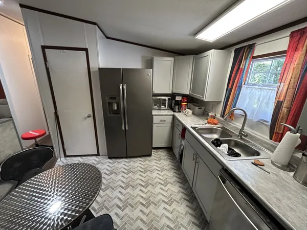 a kitchen with stainless steel appliances granite countertop a refrigerator stove and sink