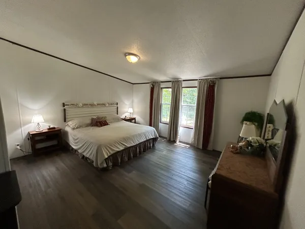 a bedroom with a bed and wooden floor