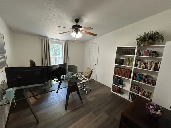 a view of a workspace with furniture and a bookshelf