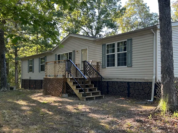 a view of a house with a yard and wooden fence