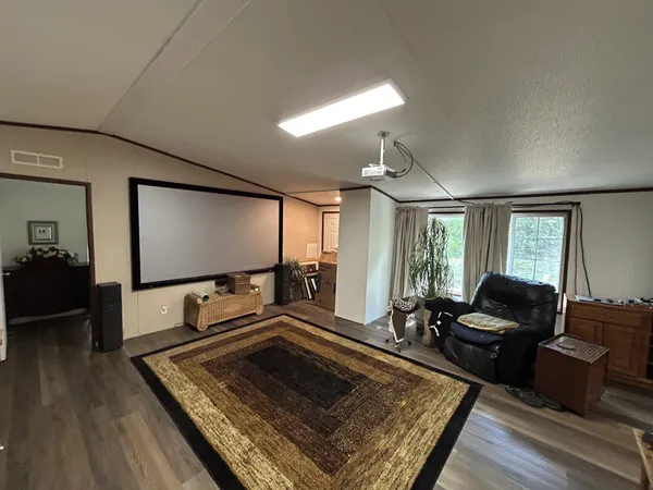 a living room with furniture flat screen tv and a large window