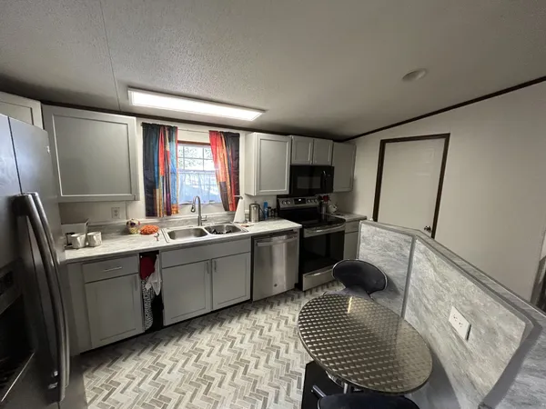 a kitchen with a sink appliances cabinets and furniture