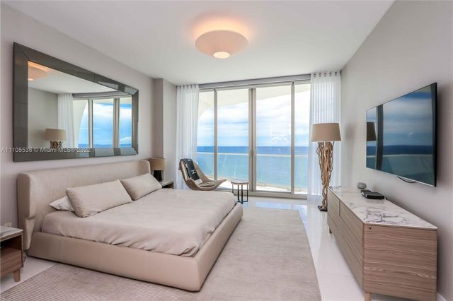 a spacious bedroom with a bed and glass windows