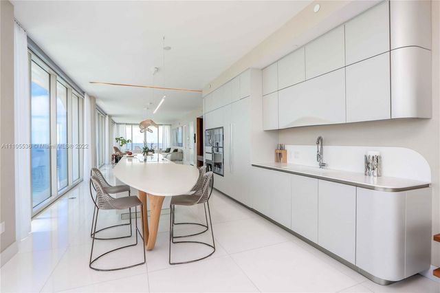 a kitchen with a table chairs and a refrigerator