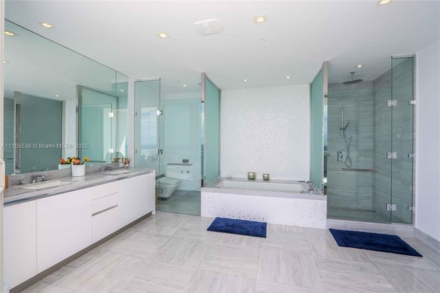 a large bathroom with a double vanity sink a large mirror and shower