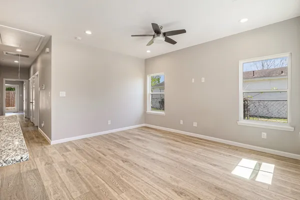 a view of an empty room with window and wooden floor
