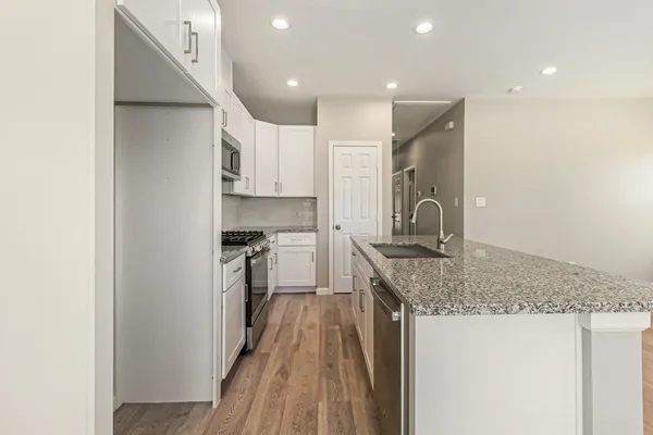 a kitchen with stainless steel appliances granite countertop a sink stove and refrigerator