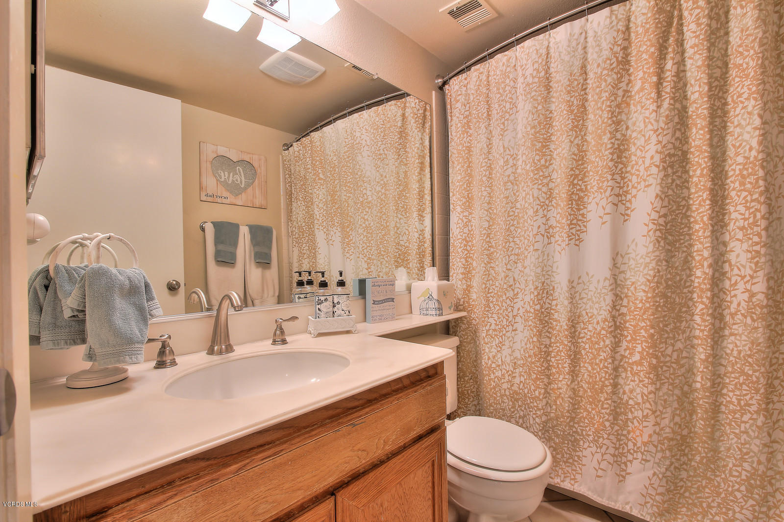 12510 Crystal Ranch Road Moorpark, CA 93021 - Photo 21 of 43 a bathroom with a sink a toilet and shower curtain