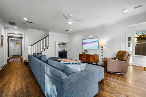 a living room with furniture wooden floor and a flat screen tv