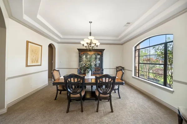 a dining room with furniture a chandelier and window